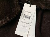a label on a brown coat with a fur collar
