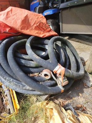 un tas de tuyaux et un sac rouge posés par terre