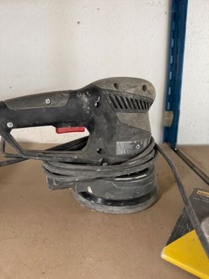 une photo d'une ponceuse posée sur une table dans un garage