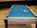 a pool table with a blue cloth on it in a room