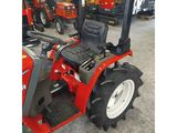 a red tractor parked in a warehouse with other tractors behind it
