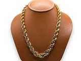 a close up of a necklace on a mannequin on a white background