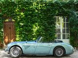 a blue sports car parked in front of a house
