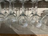 many wine glasses lined up on a shelf