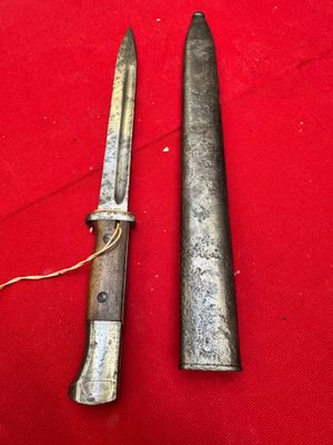 two old knives are laying on a red surface