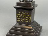 a statue of a man holding a trophy on top of a pedestal