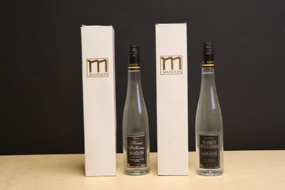 trois bouteilles de vin posées sur une table, à côté d'une boîte