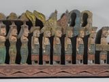 a wooden sculpture of a group of people on a boat