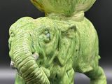 un petit éléphant vert avec un grand bol vert sur le dos