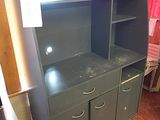une commode noire à tiroirs dans une pièce avec un rideau rouge