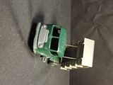 a green toy car that is sitting on a black surface