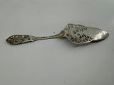 an old silver spoon sitting on top of a white table