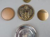 a silver plate with a gold medal on it and a silver plate with a gold medal on it