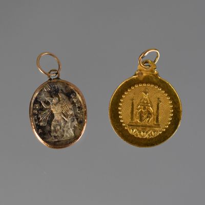 two gold and silver coin pendants with an image of a man and a woman