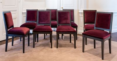 six chaises rouges disposées en cercle dans une pièce