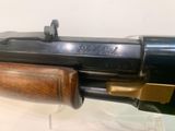 an old gun with a wooden handle on display in a glass case