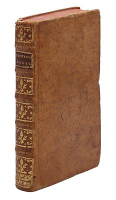 un vieux livre à la couverture brune posé sur une surface blanche