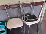 three chairs and a trash can in the corner of a room