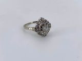 a close up of a diamond ring on a white surface
