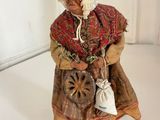 a figurine of an old woman with a basket of flowers