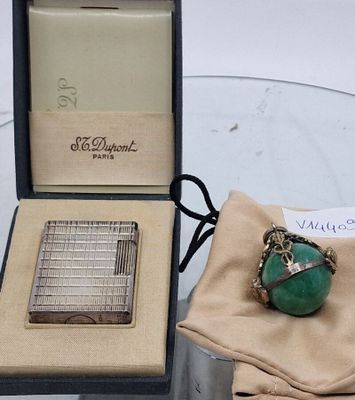 une bague sertie d'une pierre verte, posée sur une table en verre