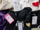a lot of clothes and a purse on a bed