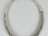 a silver necklace with a twisted design on a white background