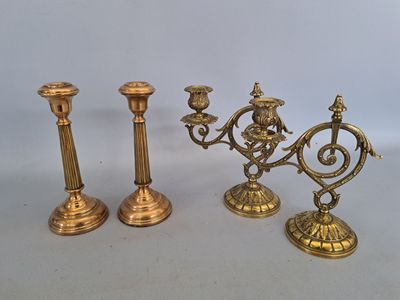 trois bougeoirs en laiton sont posés les uns à côté des autres sur une table