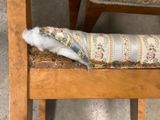 a bird that is sitting on a chair with a pillow on top of it