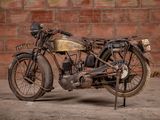a old motorcycle that is parked in front of a brick wall