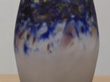 a blue and white vase sitting on a wooden table