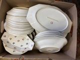 many plates and bowls in a box on the floor