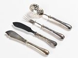 four forks, a spoon, and a knife on a white surface