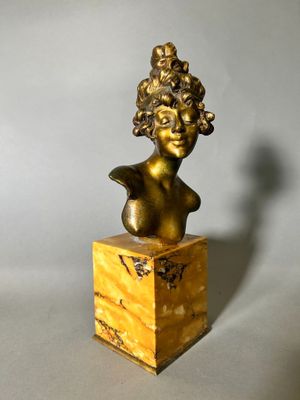 bronze bust of a woman with curly hair on a marble base
