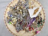 un panier rempli de différents types de bijoux posé sur une table