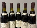 six bouteilles de vin sont alignées sur une table