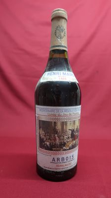 an old bottle of wine sitting on top of a red table