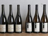 six bouteilles de vin sont alignées sur une table en bois