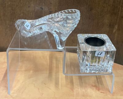 un vase en verre transparent et une paire de chaussures à talons hauts posés sur une table