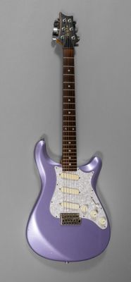 une guitare électrique violette posée sur une surface grise