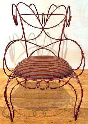 a red chair with a striped seat on a wooden floor