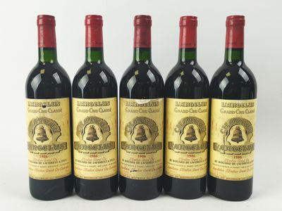 quatre bouteilles de vin sont alignées sur une surface blanche