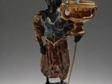 figurine of a woman holding a bowl and a stick