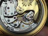 a close up of a person holding a watch in their hand