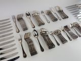 a lot of silverware on a table with a knife and fork