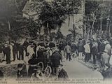 a black and white photo of a crowd of people standing in front of a building