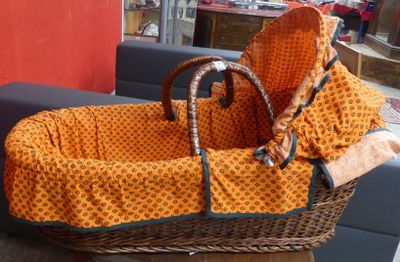 un panier en osier contenant une couverture, posé sur une table
