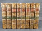 un ensemble de sept livres aux couvertures dorées et aux motifs ouvragés
