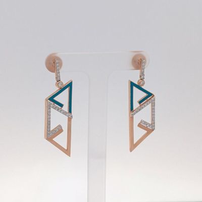 une paire de boucles d'oreilles ornées de diamants bleus et blancs, montées sur une tige transparente