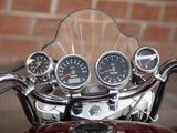a close up of a motorcycle with a clock on the handlebars